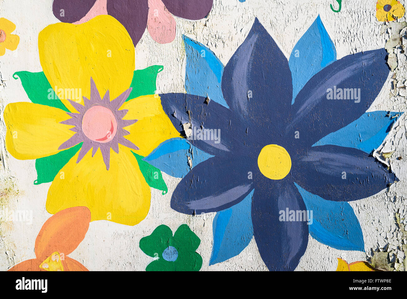 An old abandoned, peeling paint mural depicting flowers. Stock Photo