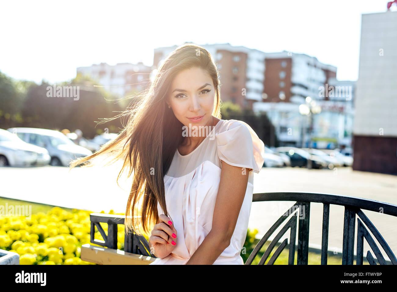 Beautiful girl sitting on a bench, sunny summer day, fashion style ...