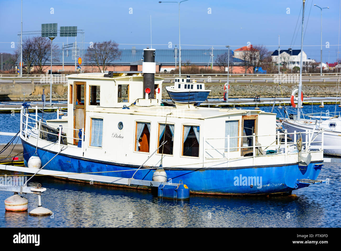 Karlskrona, Sweden - March 27, 2016: Small miniature copy of a boat placed on top of the original boat in the town marina. Stock Photo
