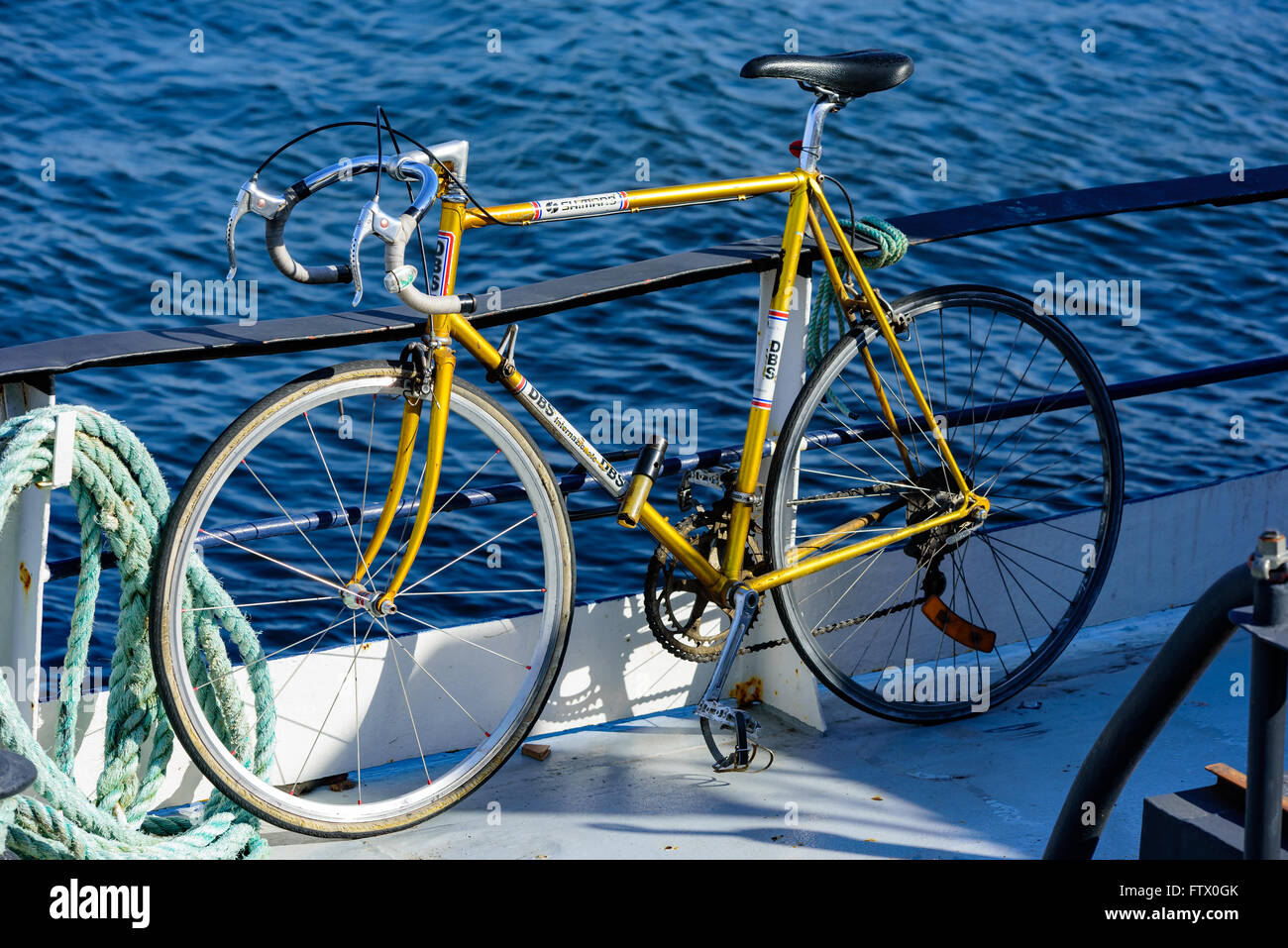 Karlskrona, Sweden - March 27, 2016: Yellow DBS bike tied to a boat railing. Stock Photo