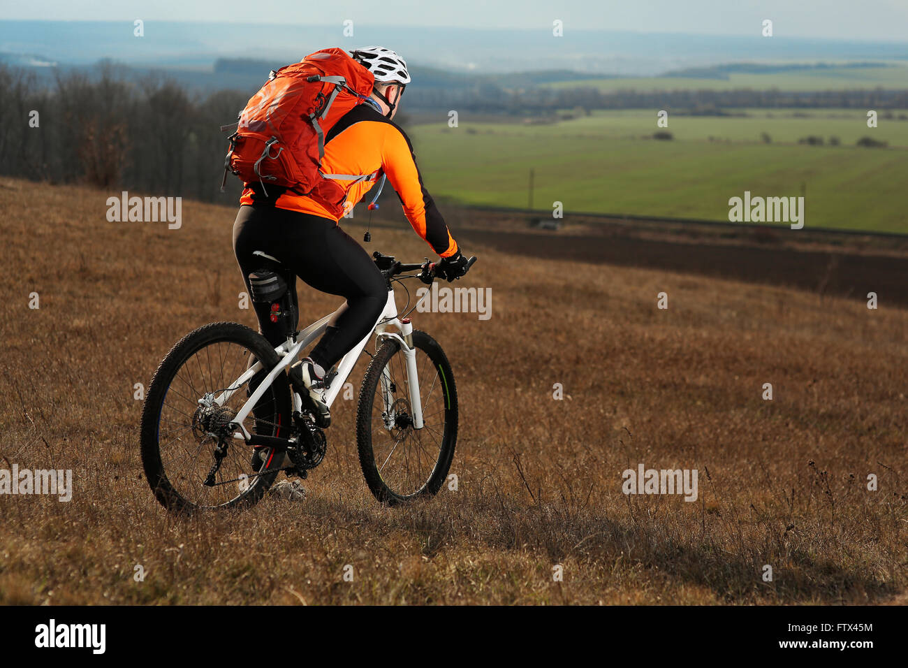 Man cyclist with backpack riding the bicycle Stock Photo - Alamy