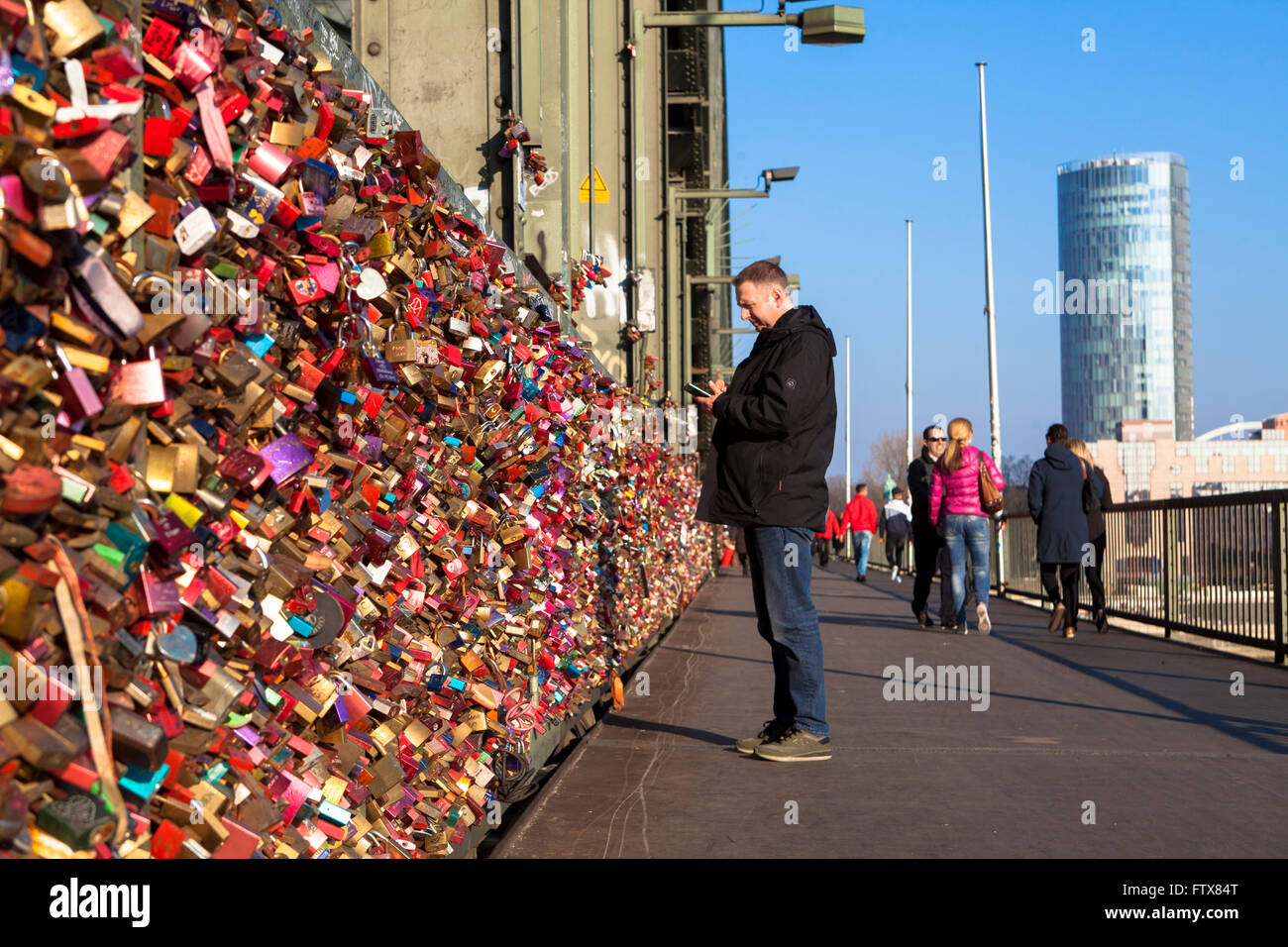 Europe, Germany, Cologne, padlocks on fence of footpath of the Hohenzollern railway bridge. Young couples seal their love with e Stock Photo