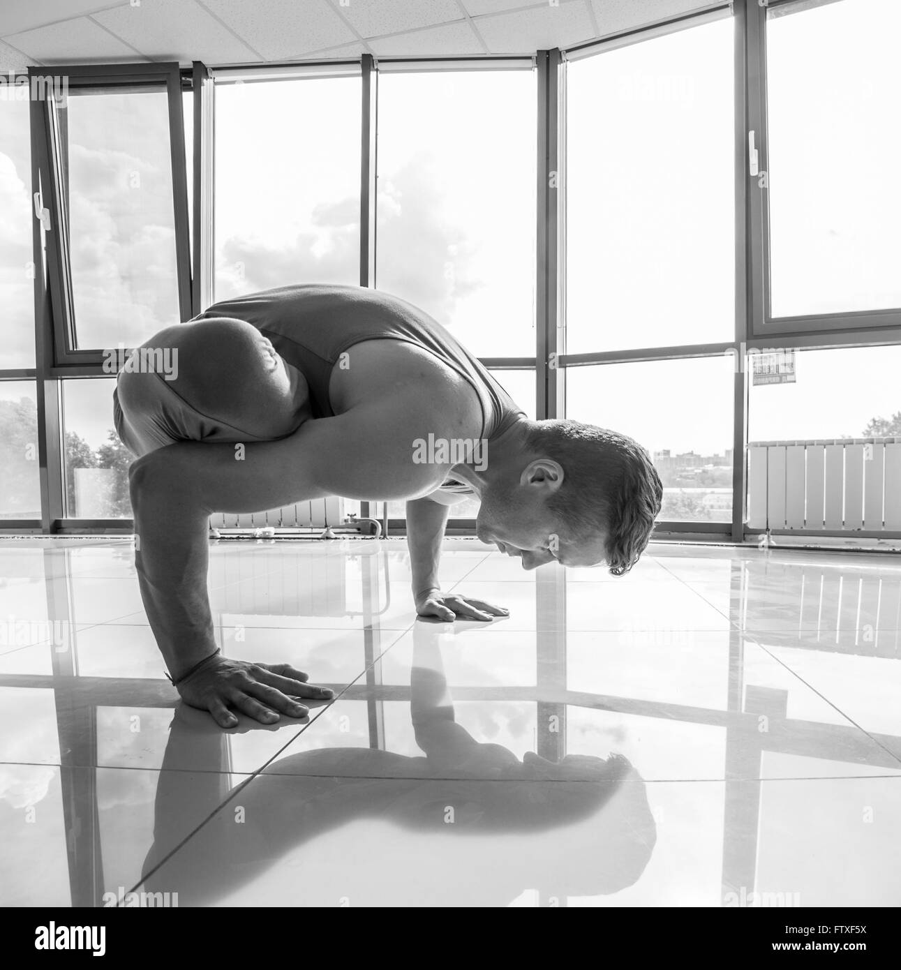 Athletic muscular young man working out, yoga, pilates, fitness training, doing side bend, asana Parighasana, Gate Yoga Pose, gr Stock Photo