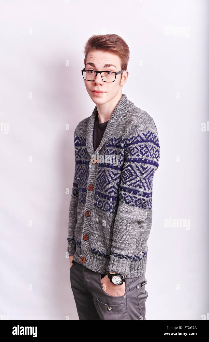 Young man with glasses on standing straight with his hands in his pockets looking straight ahead Stock Photo