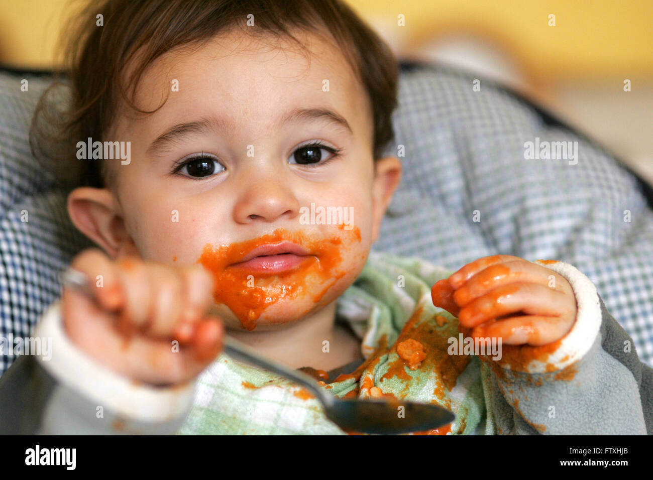 toddler enjoying feeding himself  Pic Peter Devlin Stock Photo