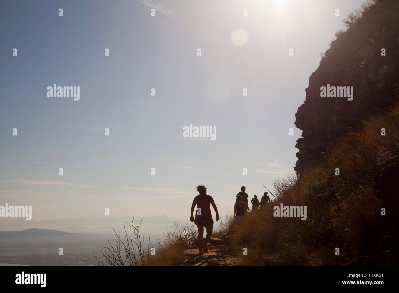 Hikers Walk Up Lions Head Early morning in Cape Town - South Africa Stock Photo