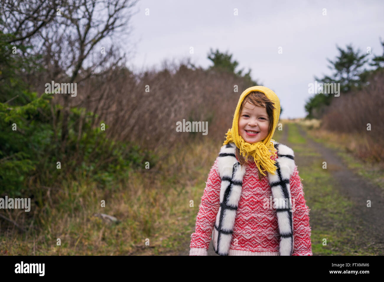 Smiling girl standing on rural footpath Stock Photo