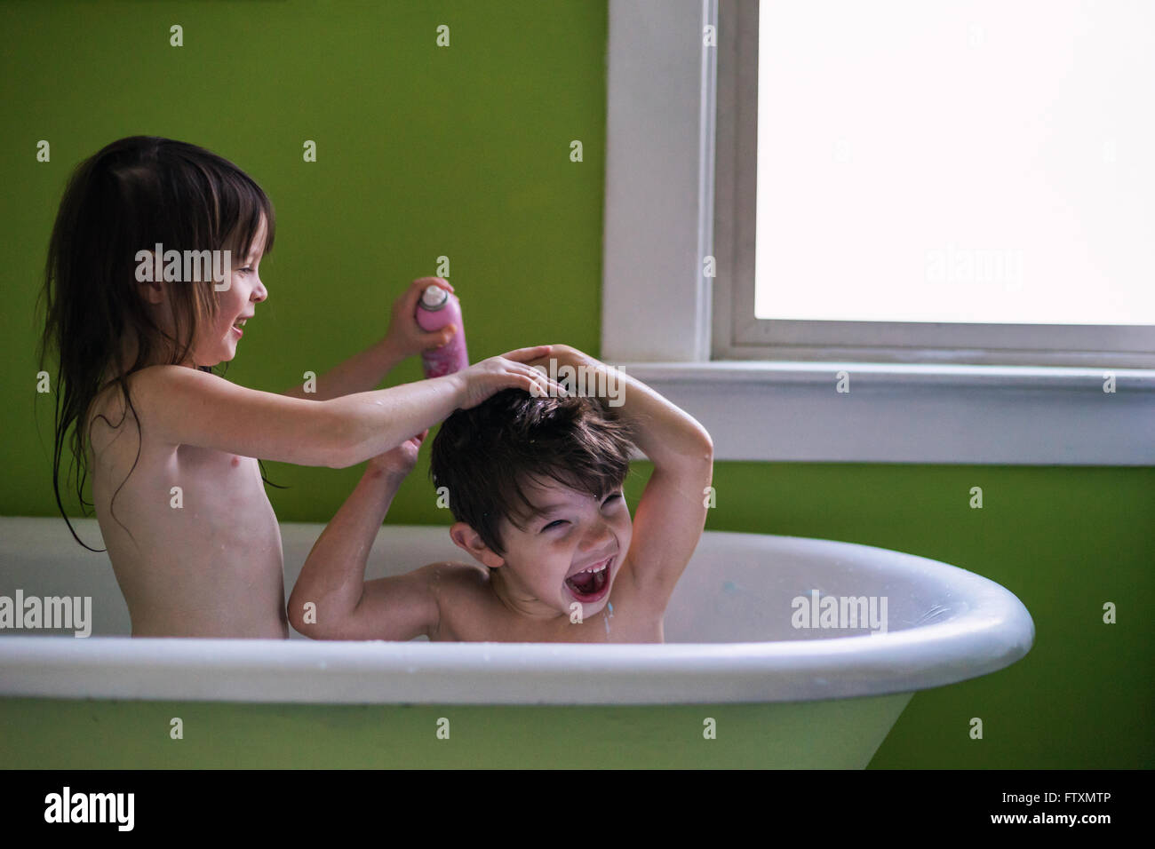 Brother and sister having a bath together Stock Photo