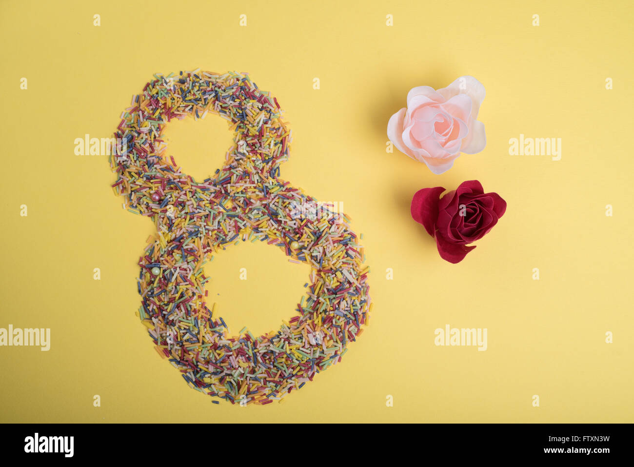 Number eight made from hundreds and thousands with flower decoration Stock Photo