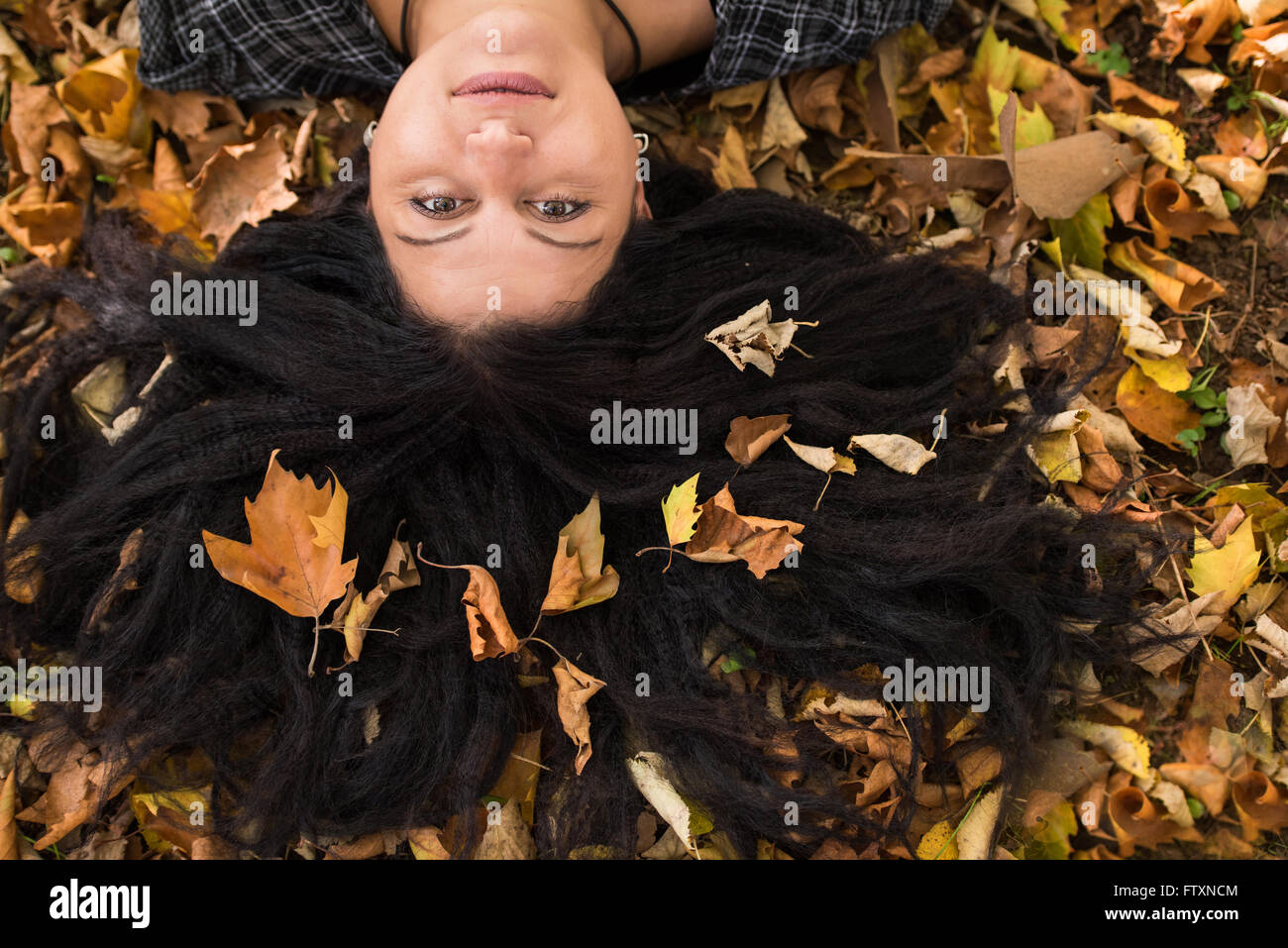 Woman lying on ground with autumn leaves in her long hair Stock Photo ...