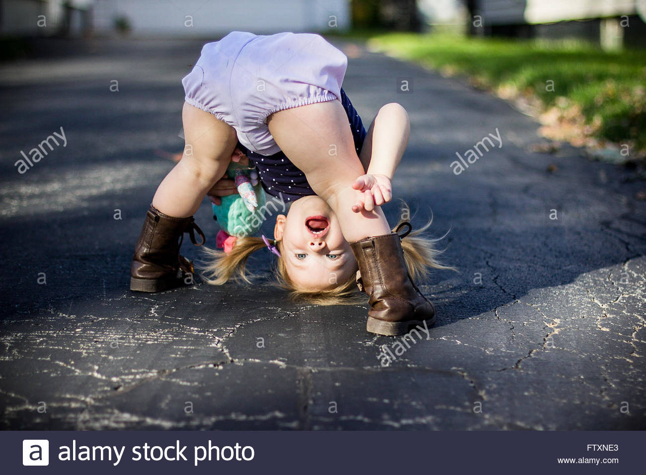 Girl Bending Over And Looking Through Her Legs Upside Down Stock Photo