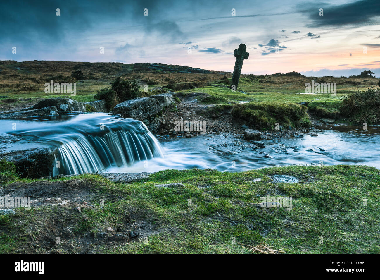 Ancient Windy Cross and wild creek in Dartmoor,UK at sunset Stock Photo