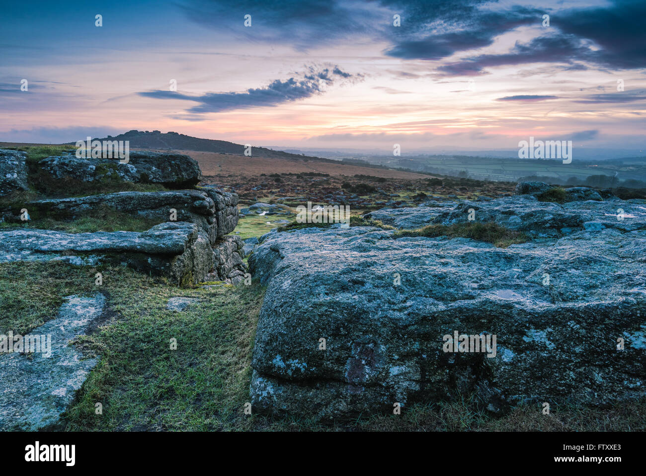 Cloudy and dramatic sky over granite rocks and hills in Dartmoor Park, UK Stock Photo
