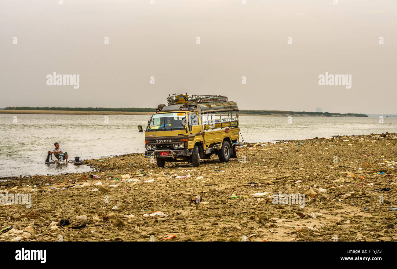 Driver washes his car in the Irrawaddy River. Stock Photo