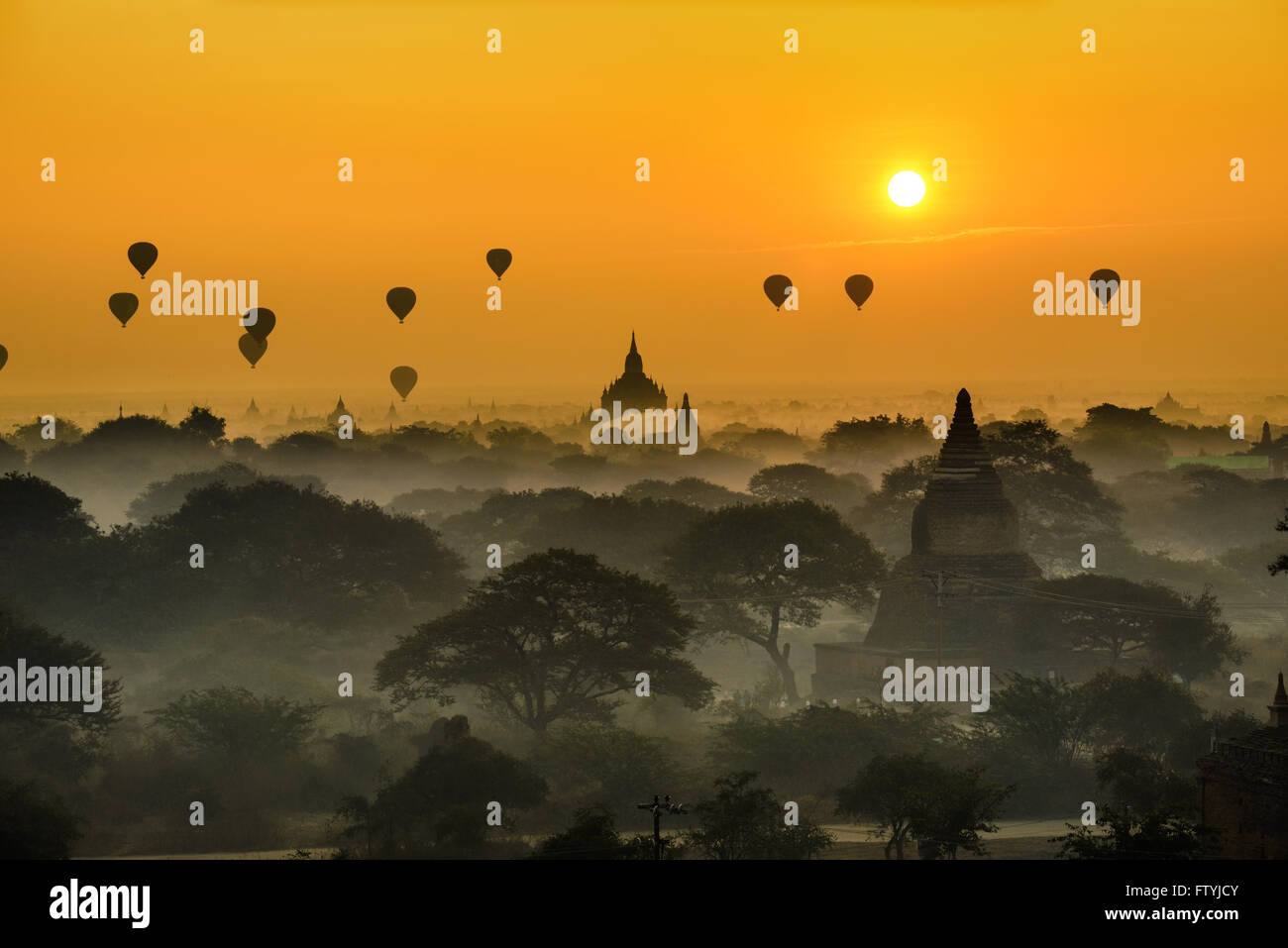 Scenic sunrise with many hot air balloons above Bagan in Myanmar. Bagan is an ancient city with thousands of historic buddhist t Stock Photo