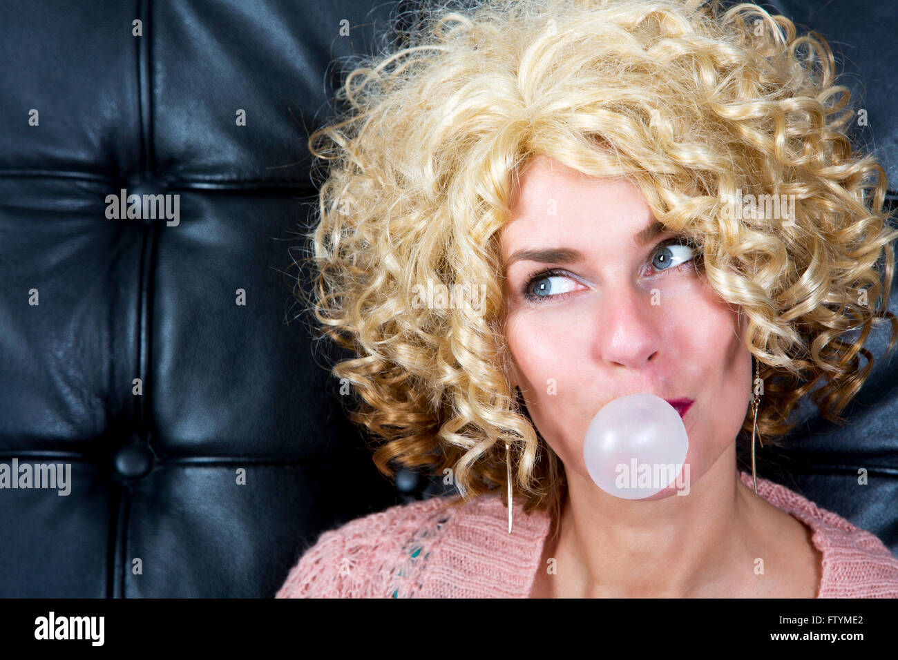 portarit of curly blond woman with bubblegum Stock Photo