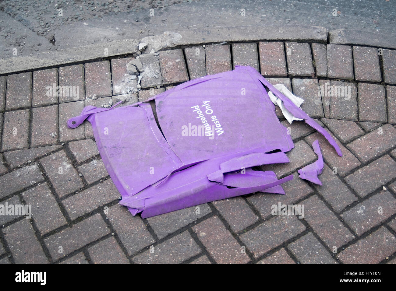 Household waste bin lies crushed on the pavement Stock Photo