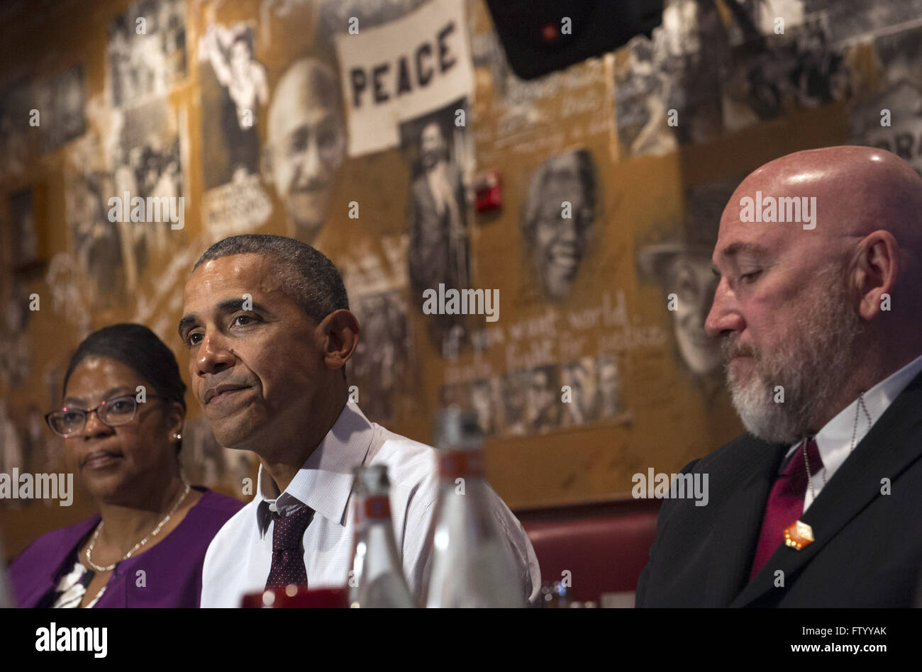 Washington, District of Columbia, USA. 30th Mar, 2016. United States President Barack Obama speaks to the media after having lunch with formerly incarcerated individuals who have received commutations, including Ramona Brant (L) and Phillip Emmert (R), at Bus Boys and Poets restaurant in Washington, DC on March 30, 2016. Obama commuted 61 additional sentences today. Credit: Kevin Dietsch/Pool via CNP © Kevin Dietsch/CNP/ZUMA Wire/Alamy Live News Stock Photo