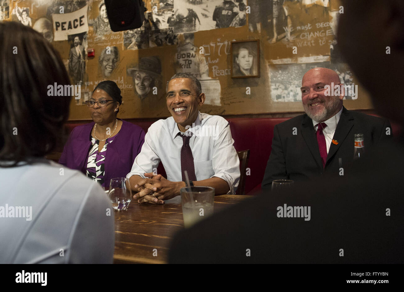 Washington, District of Columbia, USA. 30th Mar, 2016. United States President Barack Obama speaks to the media after having lunch with formerly incarcerated individuals who have received commutations, including Ramona Brant (L) and Phillip Emmert (R), at Bus Boys and Poets restaurant in Washington, DC on March 30, 2016. Obama commuted 61 additional sentences today. Credit: Kevin Dietsch/Pool via CNP © Kevin Dietsch/CNP/ZUMA Wire/Alamy Live News Stock Photo