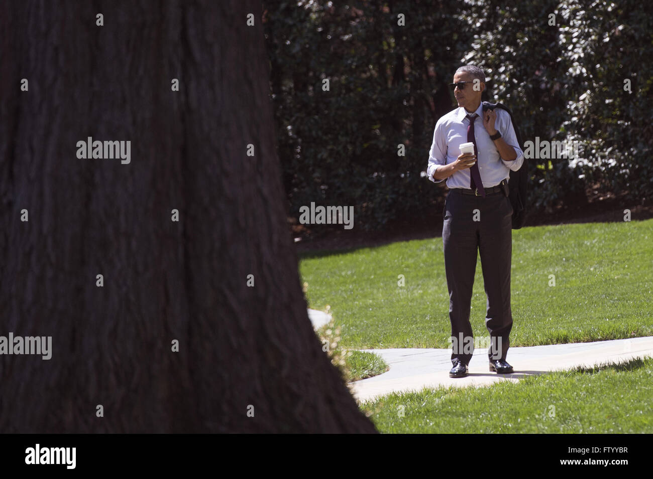 Washington, District of Columbia, USA. 30th Mar, 2016. United States President Barack Obama waits on the South Lawn as he returns to the White House after having lunch with formerly incarcerated individuals who have received commutations, in Washington, DC on March 30, 2016. Credit: Kevin Dietsch/Pool via CNP © Kevin Dietsch/CNP/ZUMA Wire/Alamy Live News Stock Photo