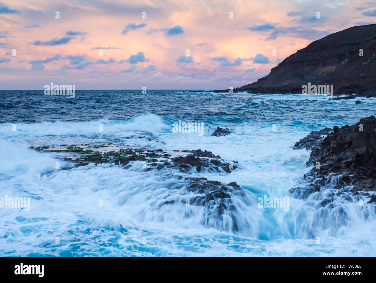 Las Palmas, Gran Canaria, Canary Islands, Spain, 30th March 2016. Weather: Warnings have been issued for heavy rain and rough seas as a mass of cold air sweeps across the Canary Islands. PICTURED: a stormy Atlantic Ocean on the rugged north coast of Gran Canaria at sunset Credit:  Alan Dawson News/Alamy Live News Stock Photo