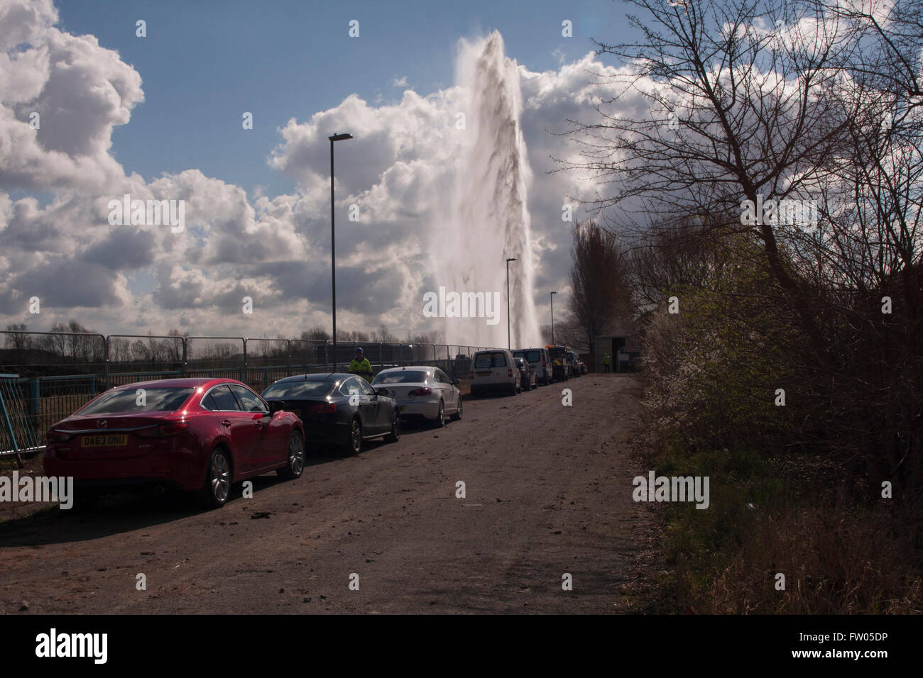 Halewood, Knowsley, UK. 31st March, 2016. A huge plume of water spraying into the sky over the old Bridgefield forum in Halewood Knowsley.Contractors have damaged the main pipe feeding a number of homes in the Halewood area. Credit:  Paul Scoullar/Alamy Live News Stock Photo