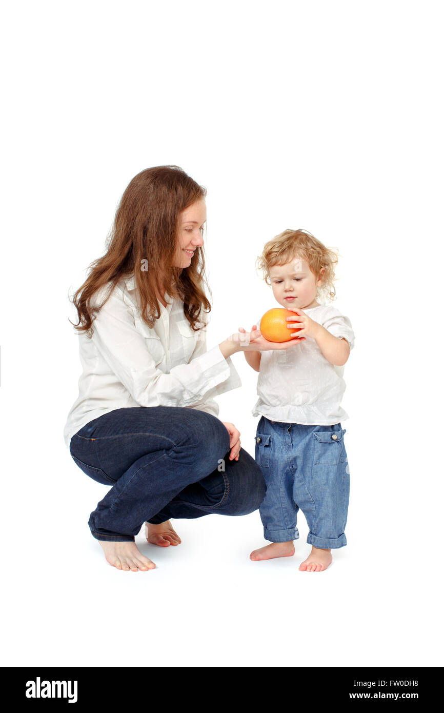 Mom gives child grapefruit Stock Photo