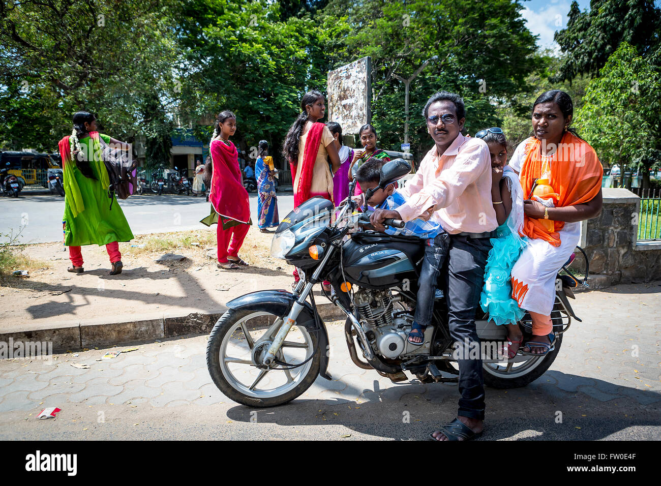 Indian family of 4 all sat astride a Bajaj motorcycle at the side of a street in Tindivanam, Viluppuram, Tamil Nadu, Asia Stock Photo