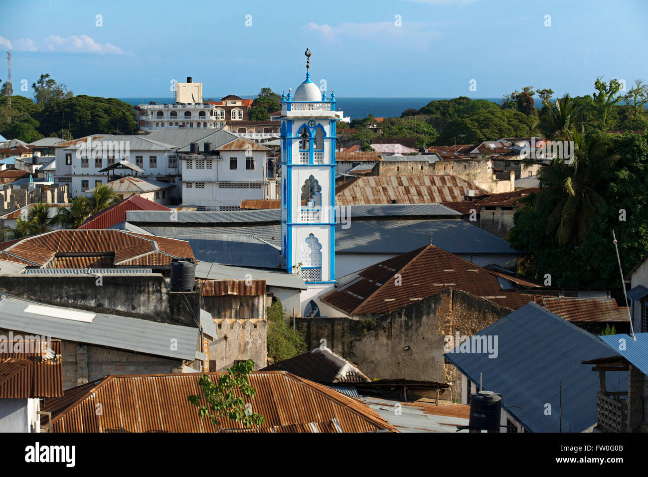 Minaret of one of the mosques in Stone Town, Zanzibar, Tanzania. The sunset invites to look for some terrace or highest point of Stock Photo