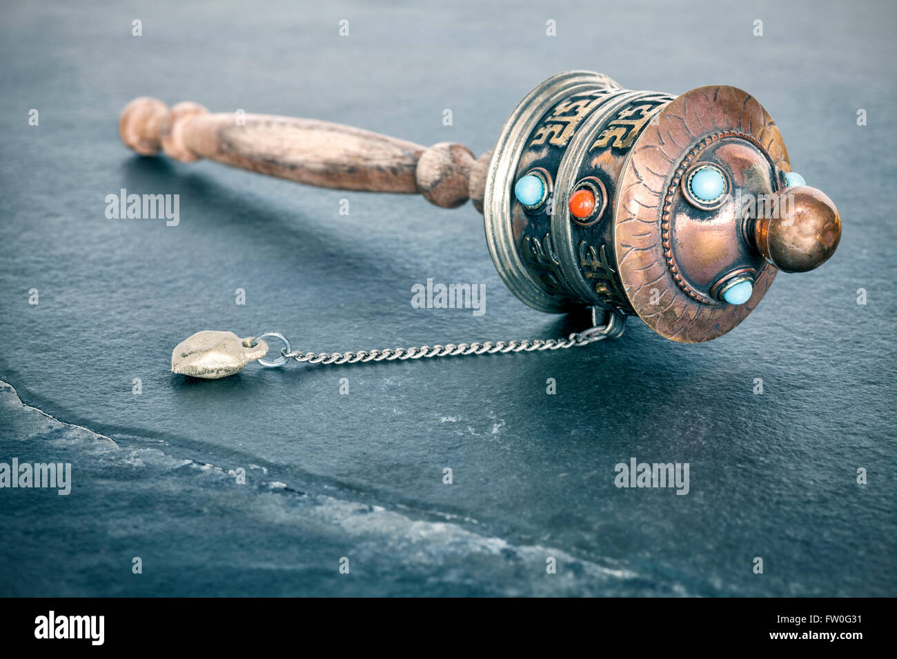 Vintage toned old Tibetan prayer wheel used to accumulate wisdom and good karma and to purify bad karma, shallow depth of field. Stock Photo