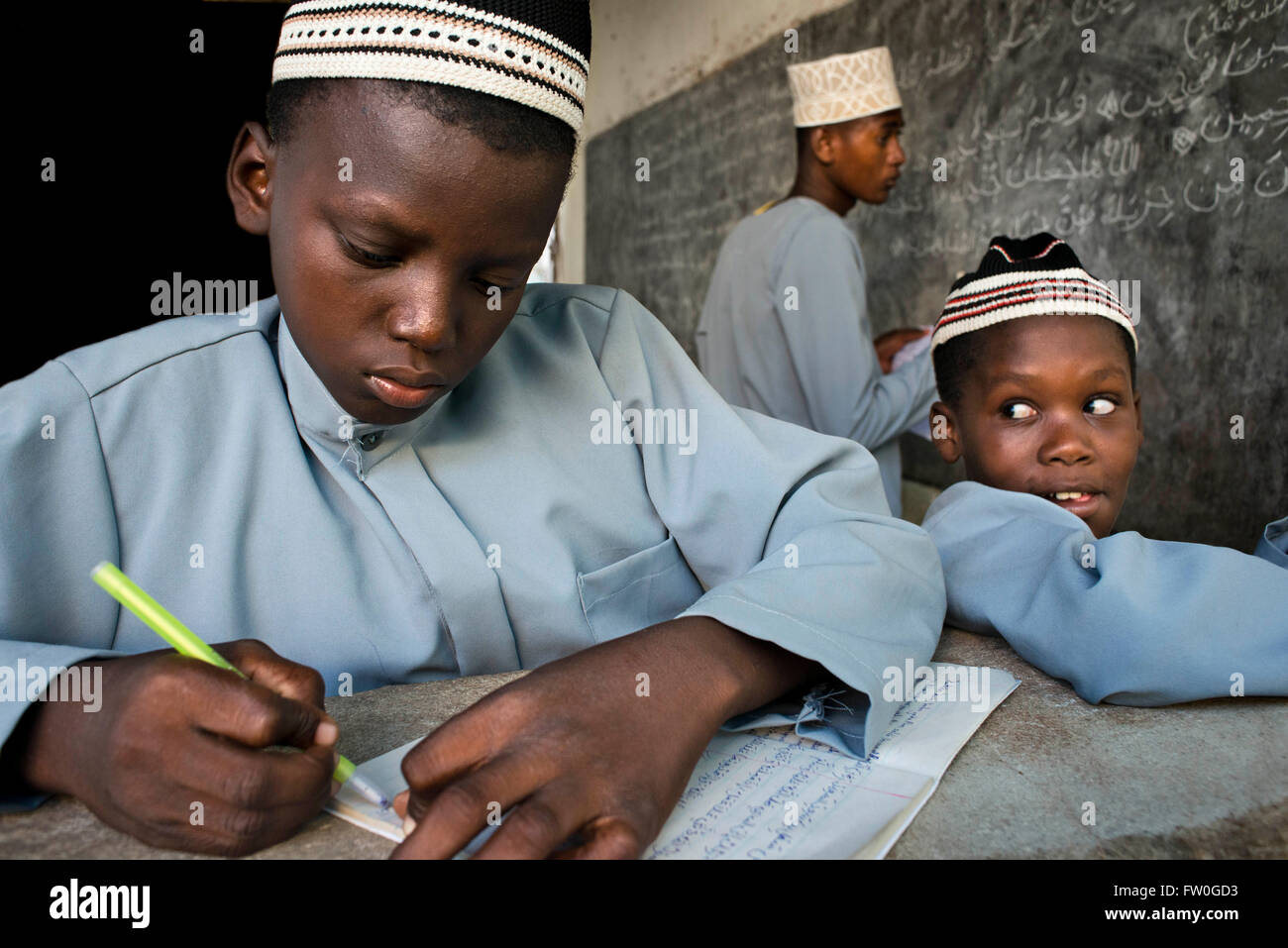 Young Boy in Madrassa (Koranic School). Kizimkazi Dimbani, Zanzibar, Tanzania. Practicing and writting studies of muslim religio Stock Photo