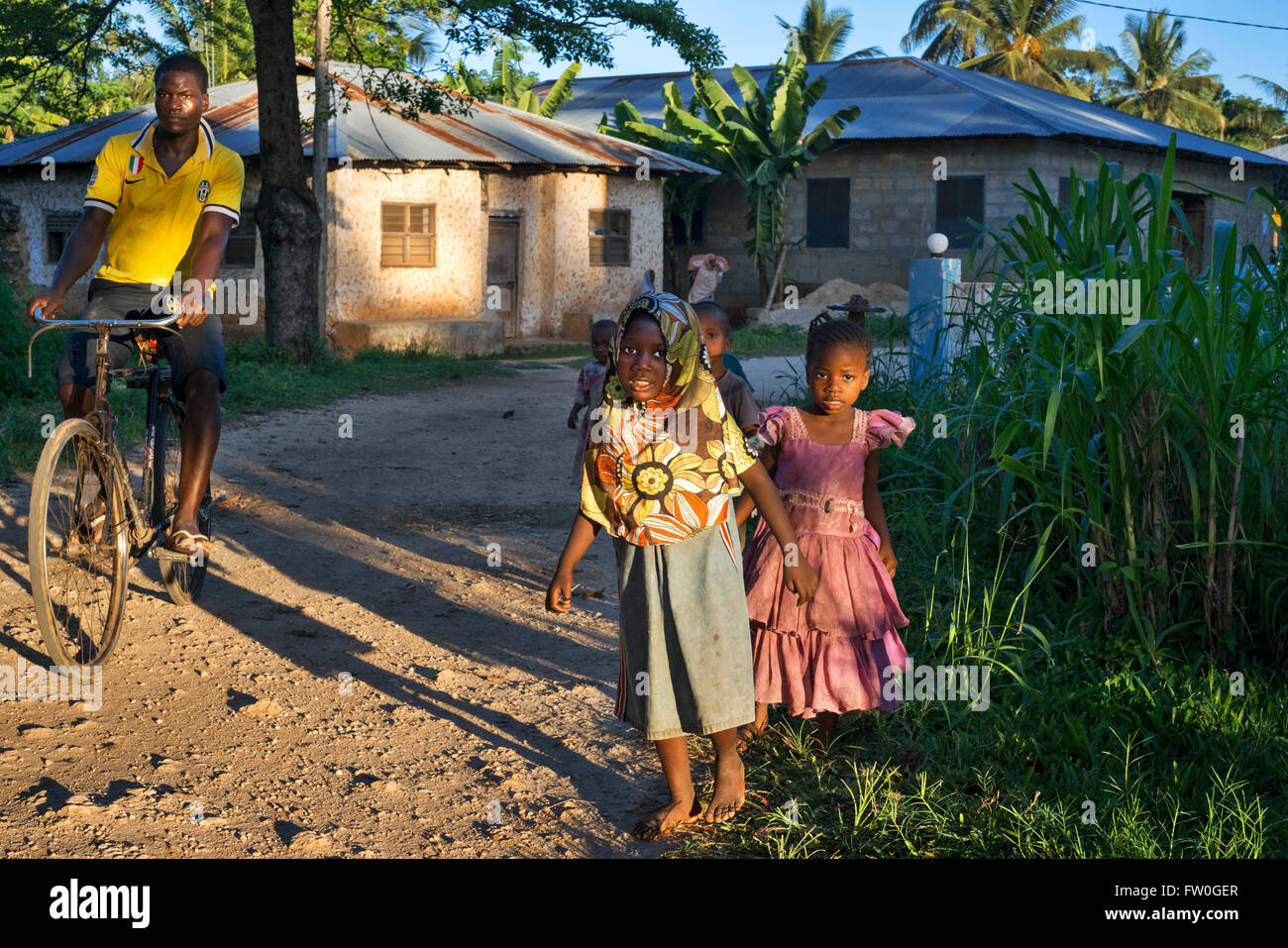 Young girls and bicycle in Kizimkazi Dimbani village, West coast, Zanzibar, Tanzania. Stock Photo
