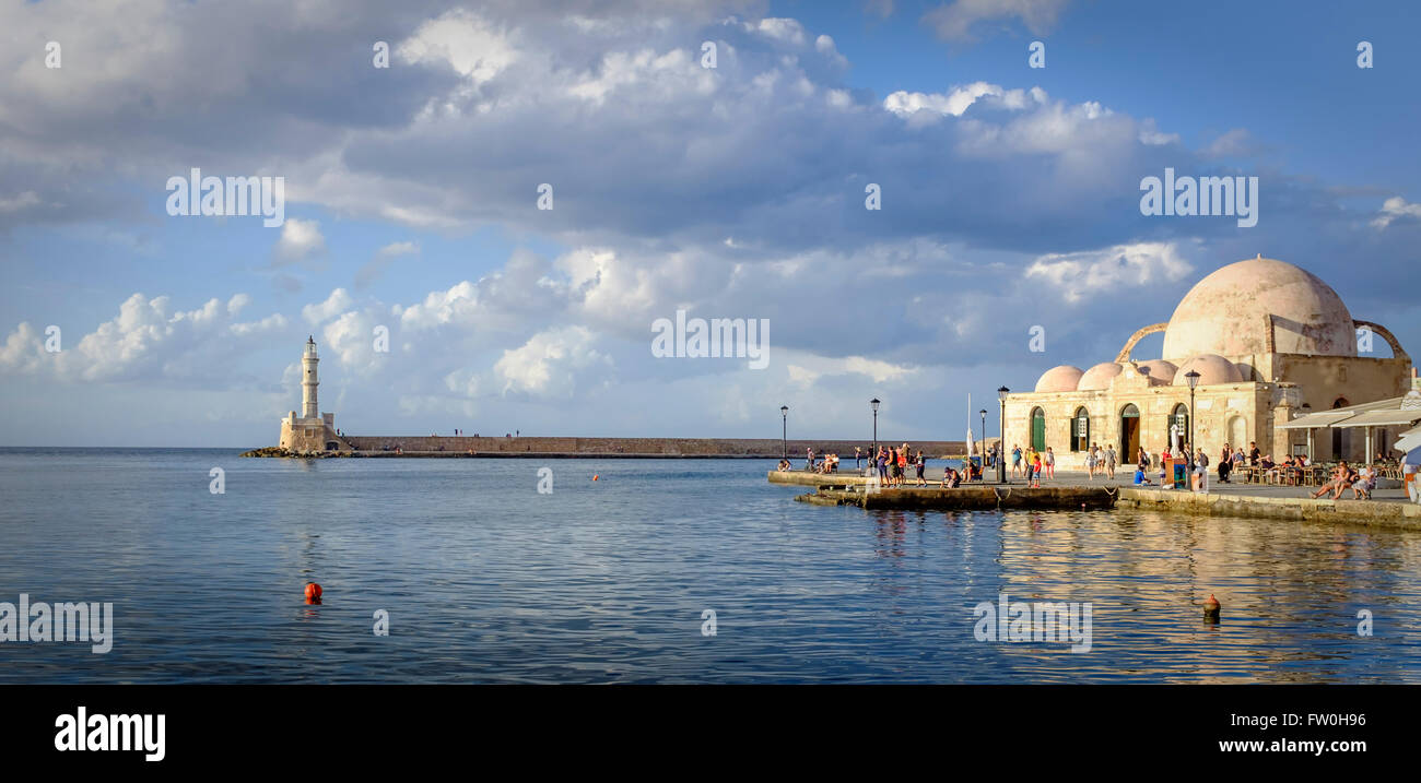 Chania harbour, Crete, Greece, showing Venetian lighthouse and tourists on the Mosque of Jannissaries waterfront. Chania was an Ancient Minoan city. Stock Photo