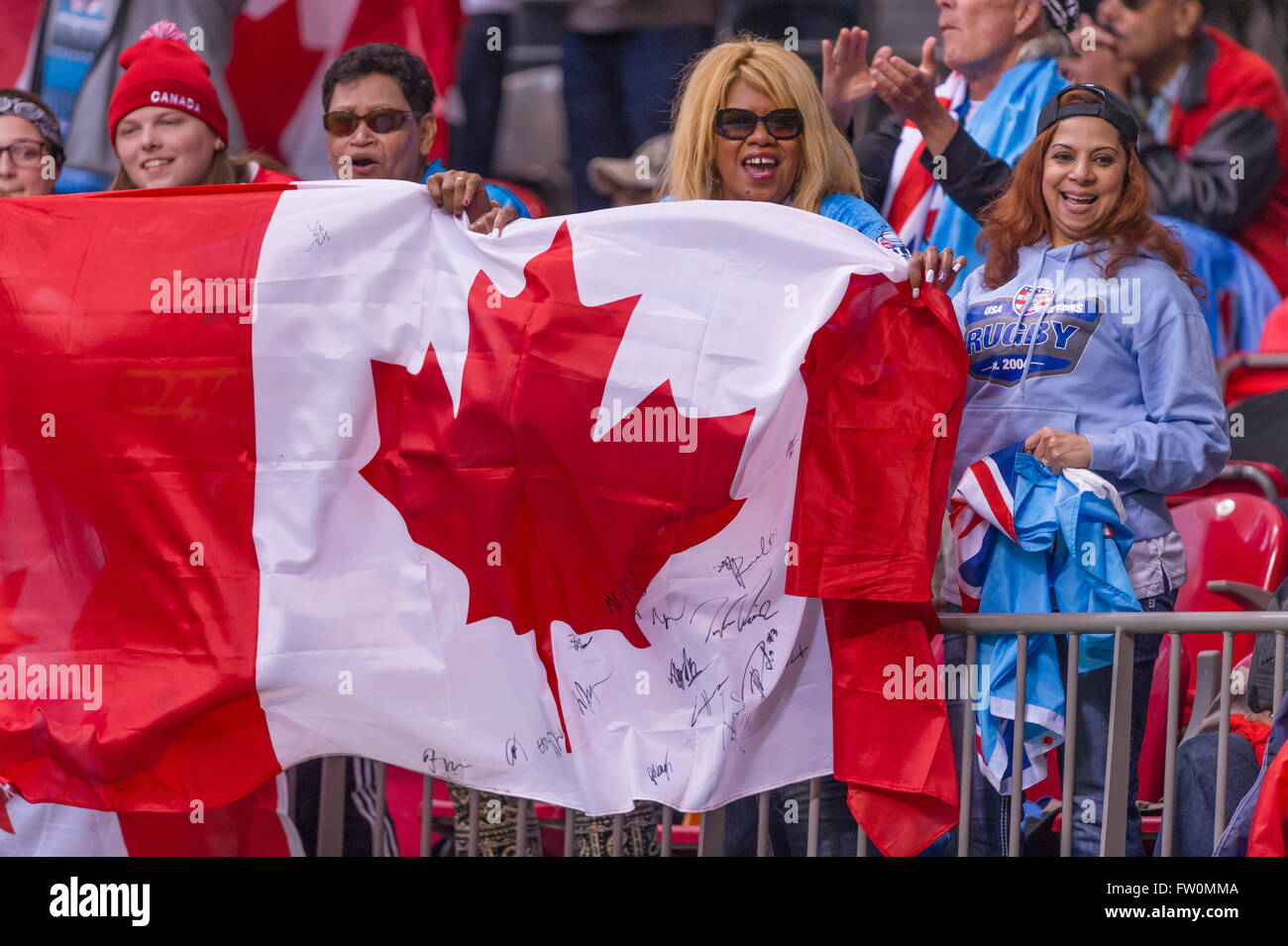 Exuberant fans with Canadian flag at a sporting event, at BC Place Stadium Vancouver Stock Photo