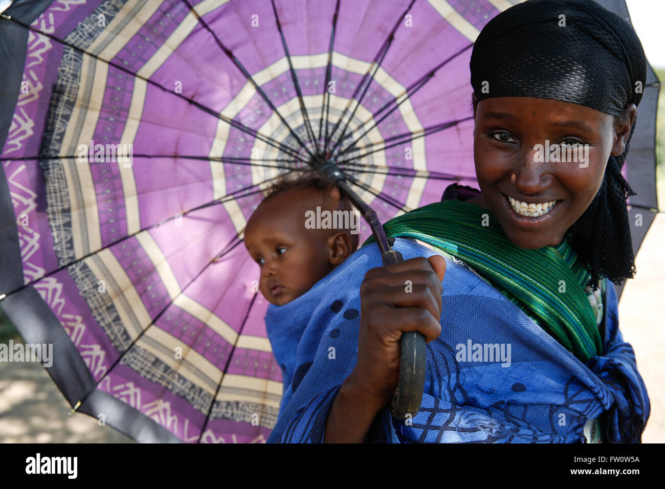 Between Mojo and Ziway, Ethiopia, October 2013: A young mother shelters her baby son from strong sun with her umbrella.   Photograph by Mike Goldwater Stock Photo