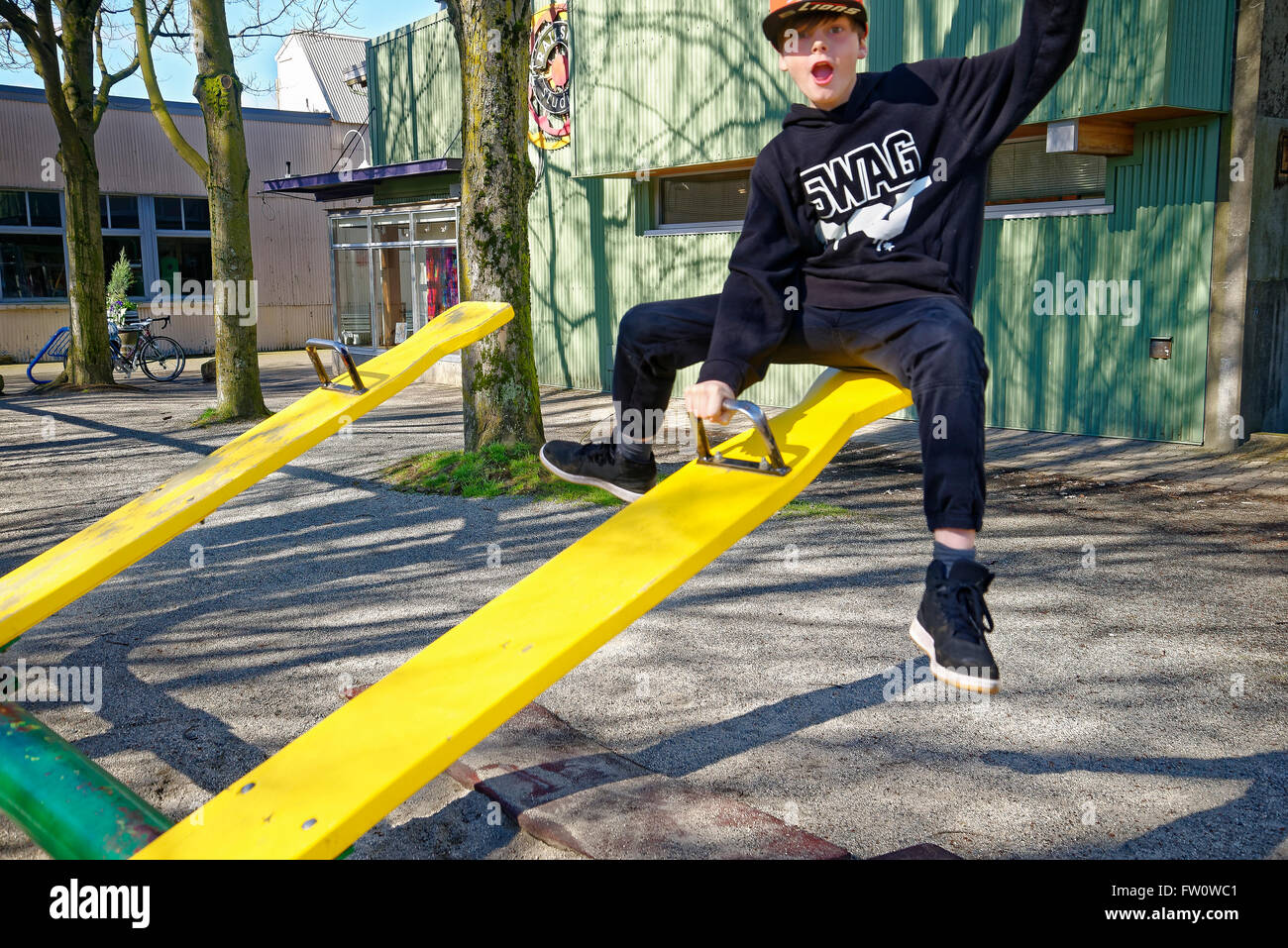Boy on teeter totter see-saw Stock Photo