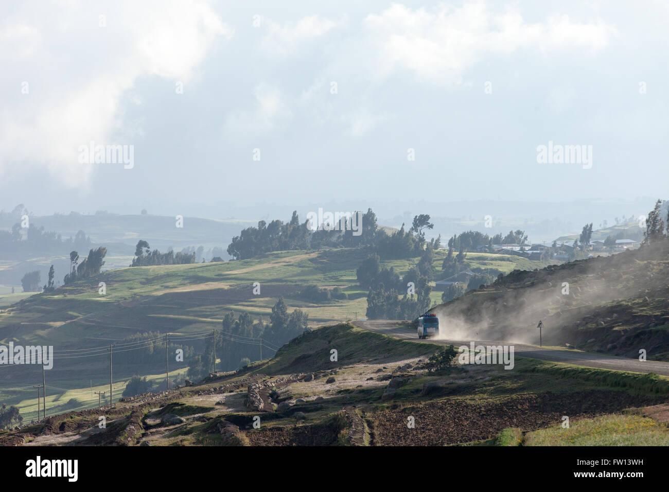 Furamariam village, Debele, Amhara, Ethiopia, October 2013:  A bus kicks up dust on the road through the windswept valley. Stock Photo