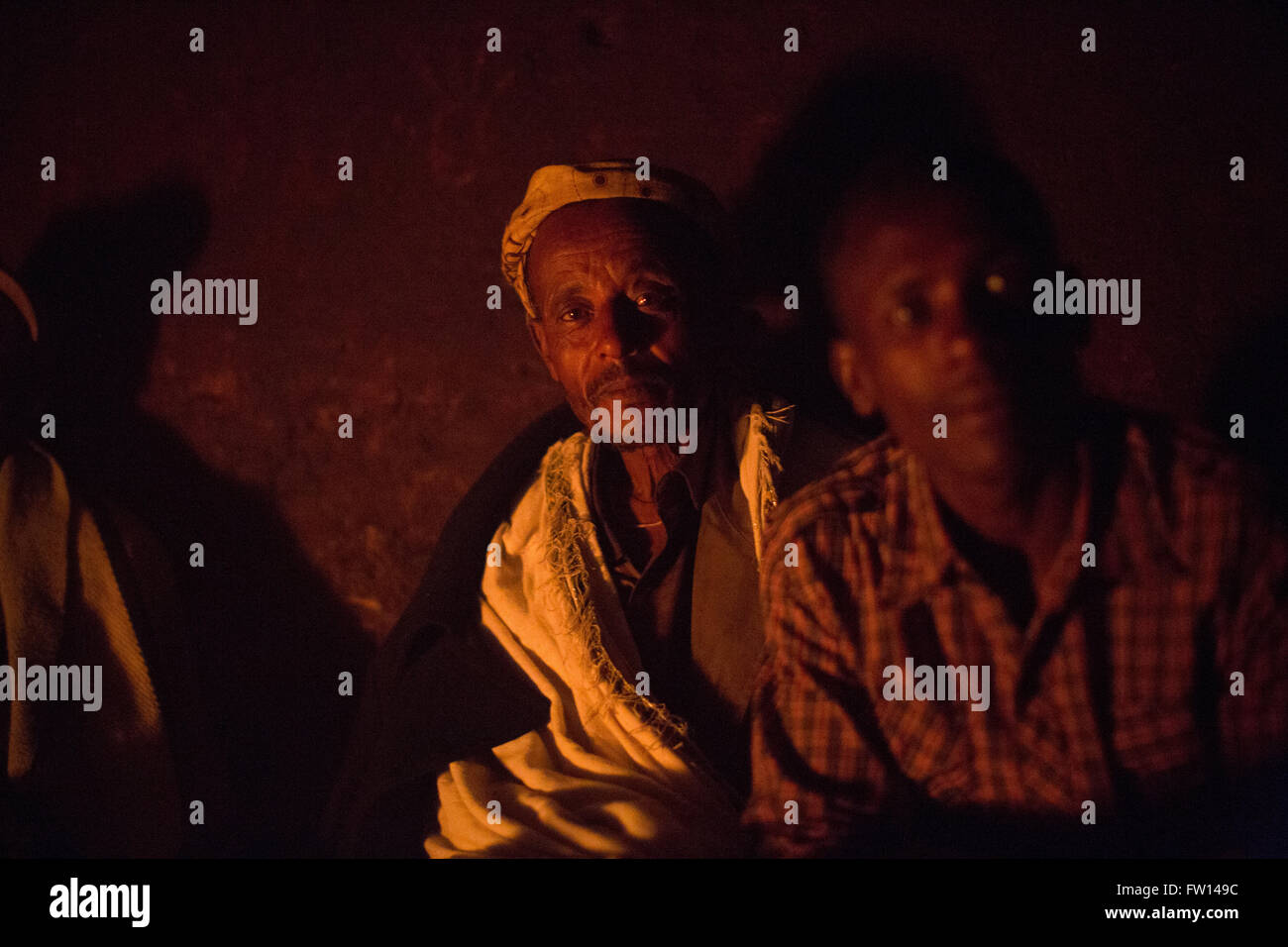 North Shewa,  Ethiopia, 2013:  Farmers enjoy a glass of home-made araki around a fire. Stock Photo