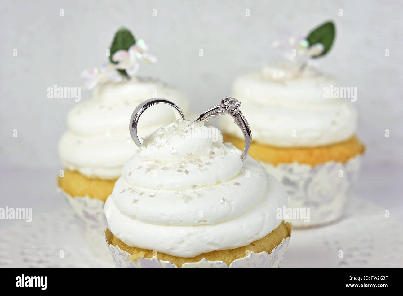 Pair of wedding rings in cupcake frosting with star sprinkles. Stock Photo