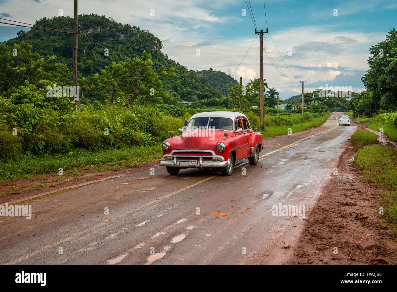 Red old american car drive on rural road in Cuban mountains Stock Photo