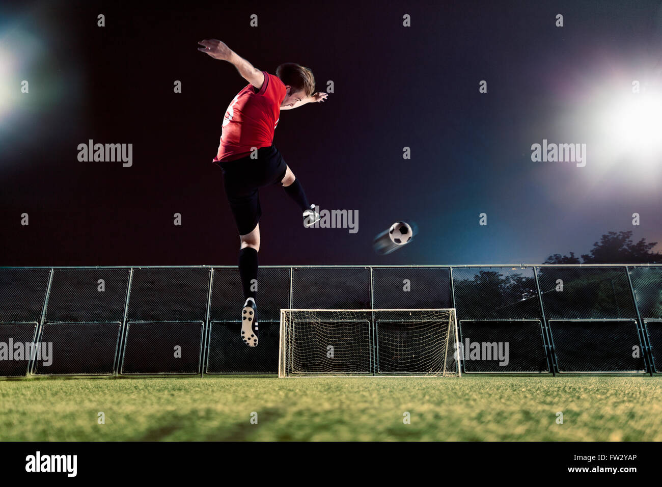 Athlete kicking soccer ball towards goal Stock Photo - Alamy