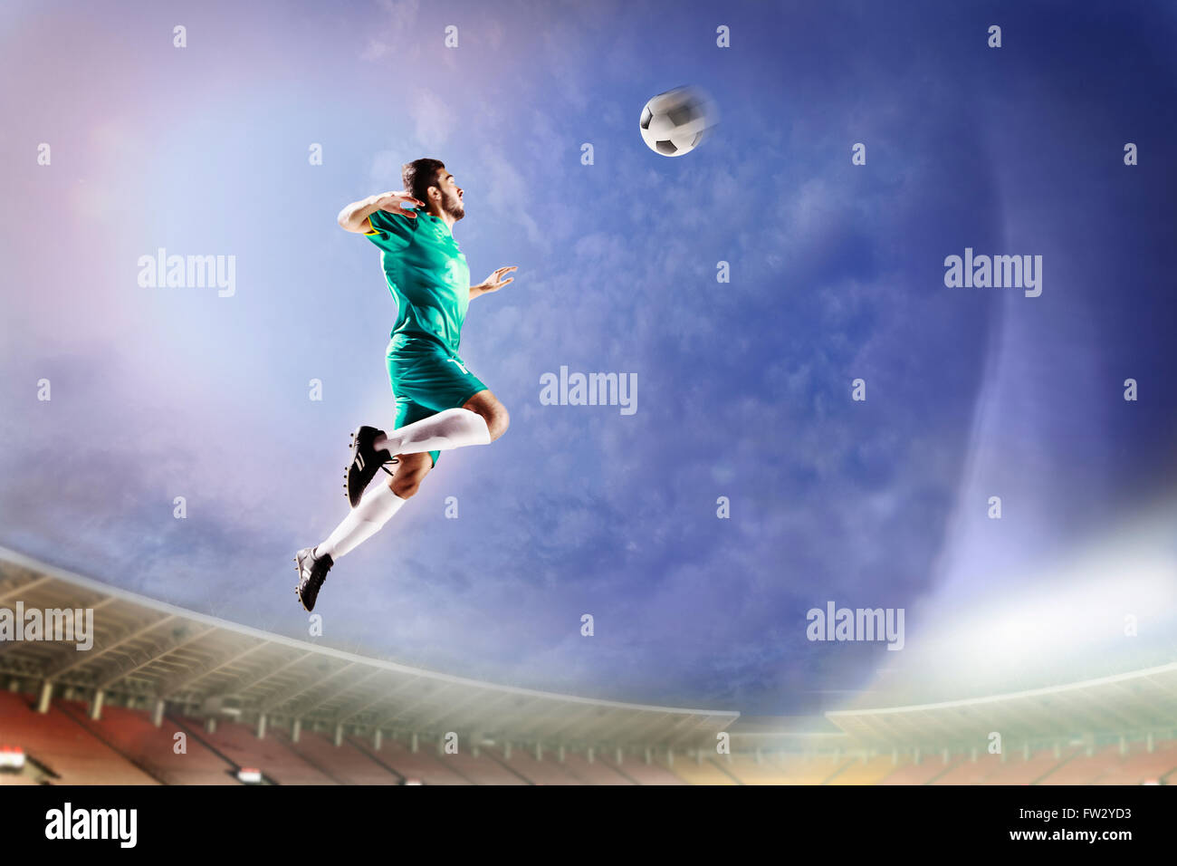Athlete heading soccer ball in stadium Stock Photo Alamy