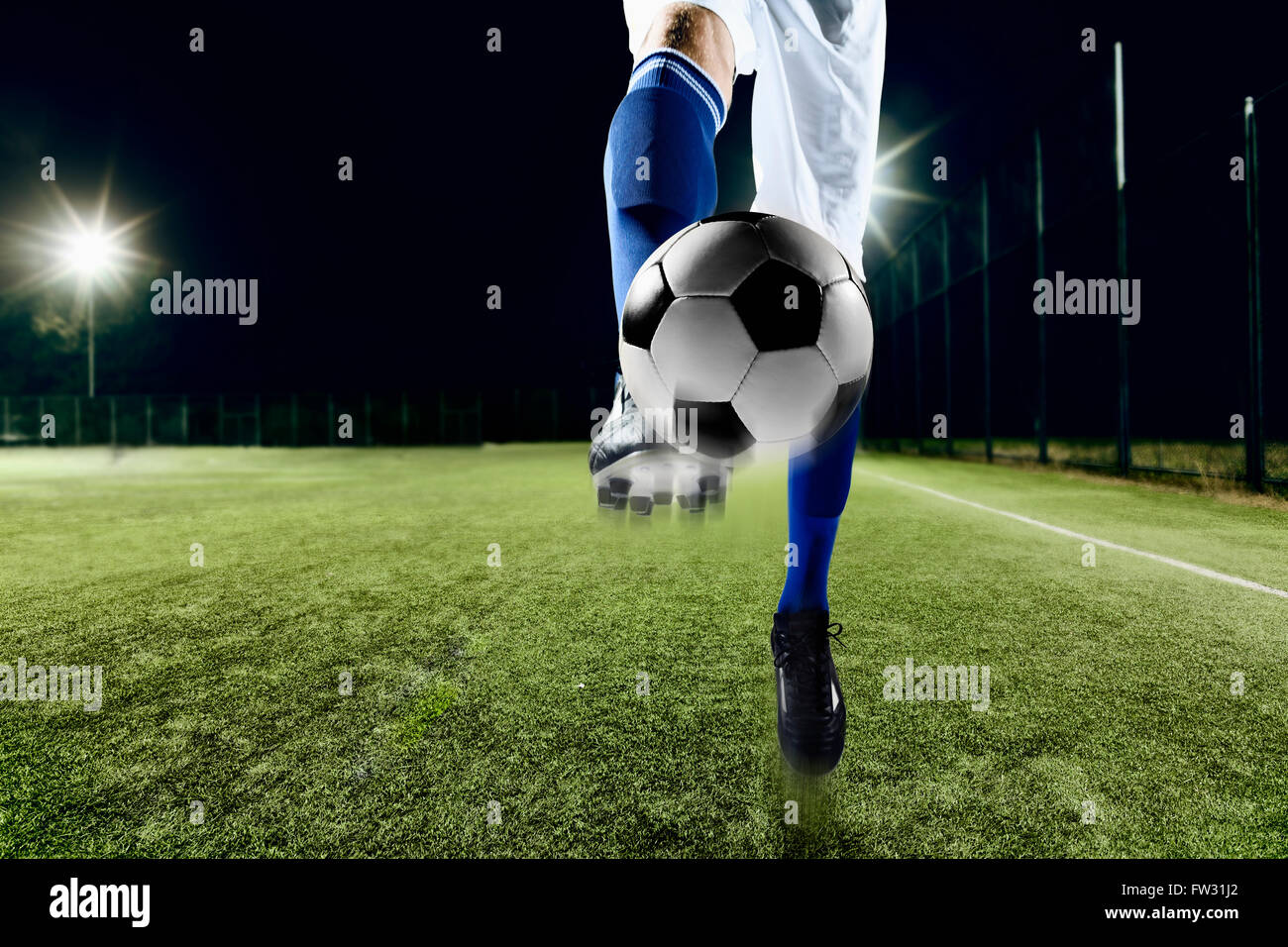 Athlete kicking soccer ball Stock Photo - Alamy