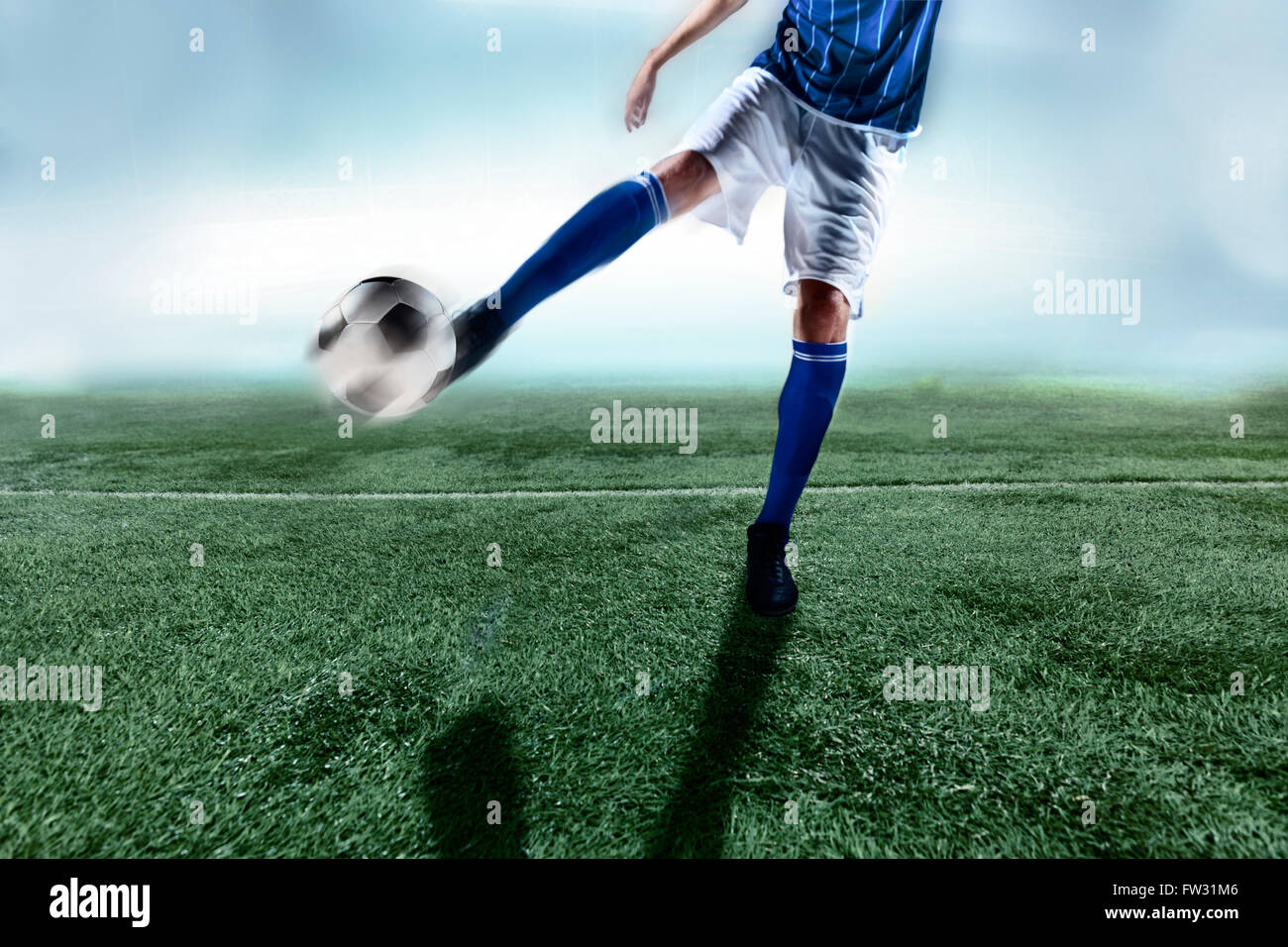 Athlete kicking soccer ball Stock Photo - Alamy