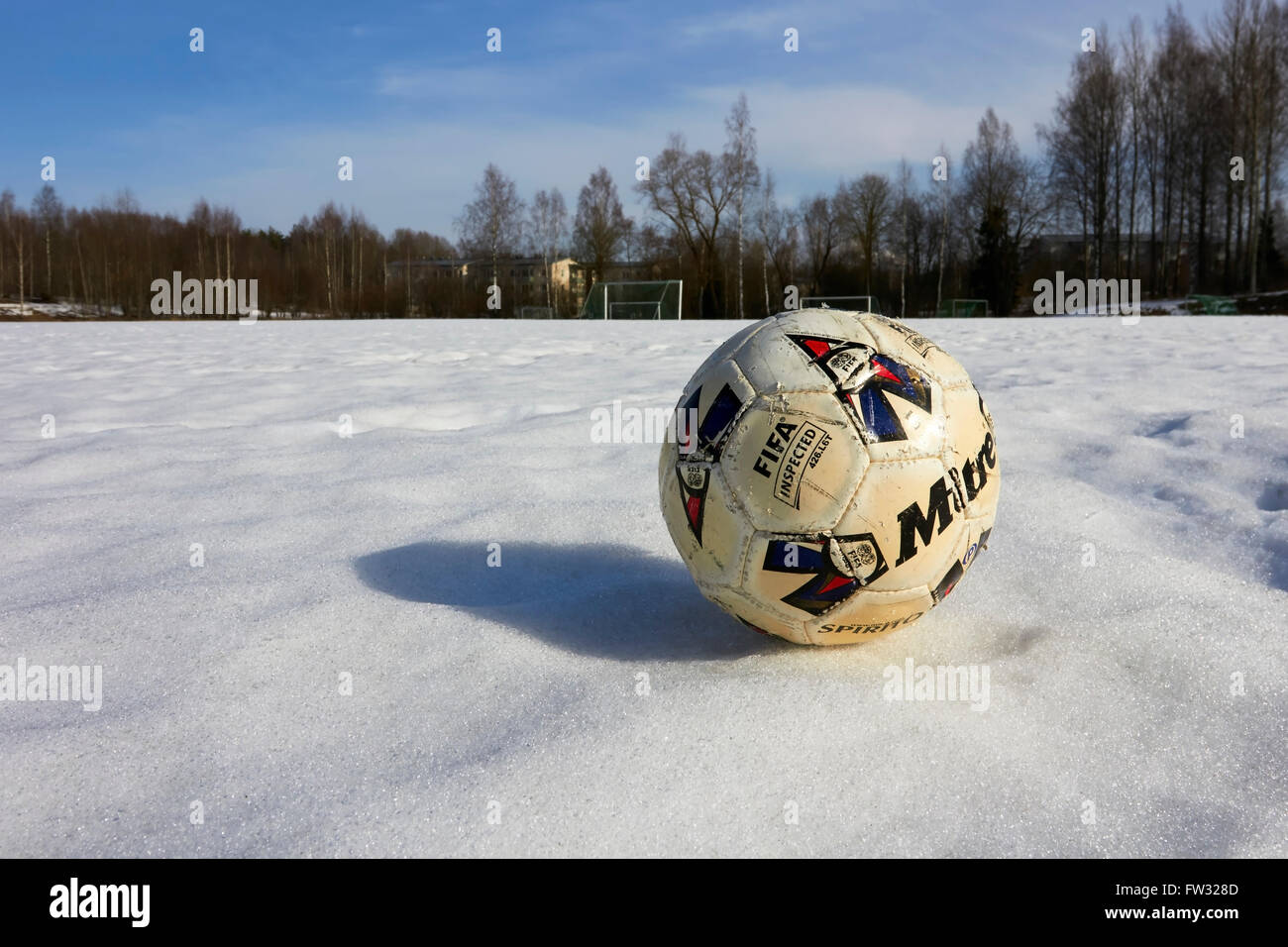 worn-out football on snow Stock Photo