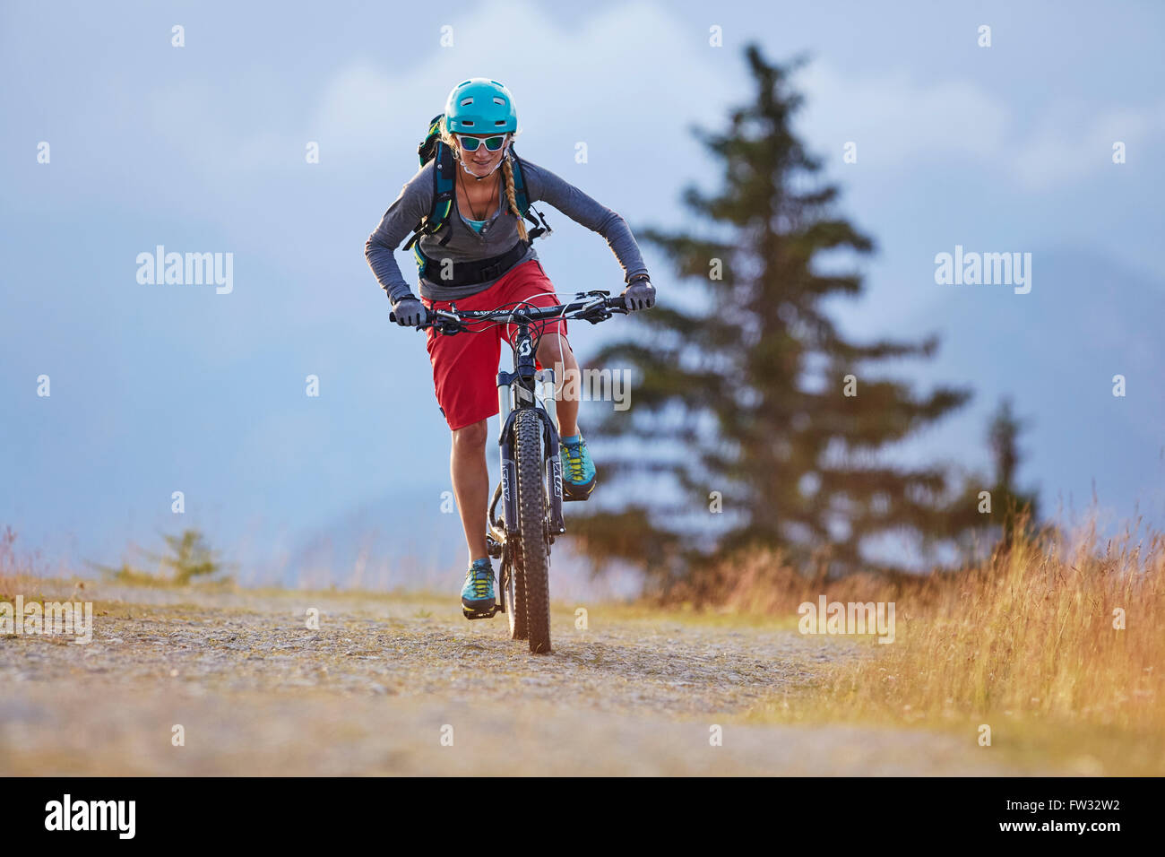 Mountain biker with a helmet riding on a gravel road, Mutterer Alm near Innsbruck, Tyrol, Austria Stock Photo