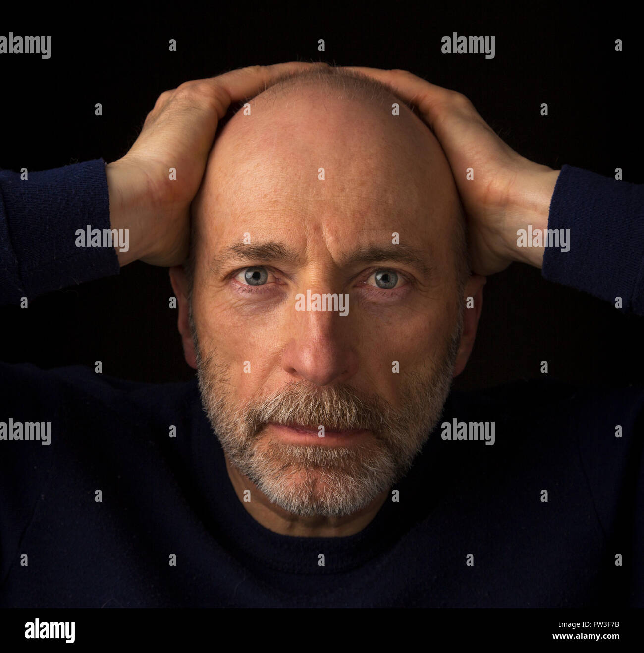 60 years old  bald man with a beard - a head shot against a black background Stock Photo