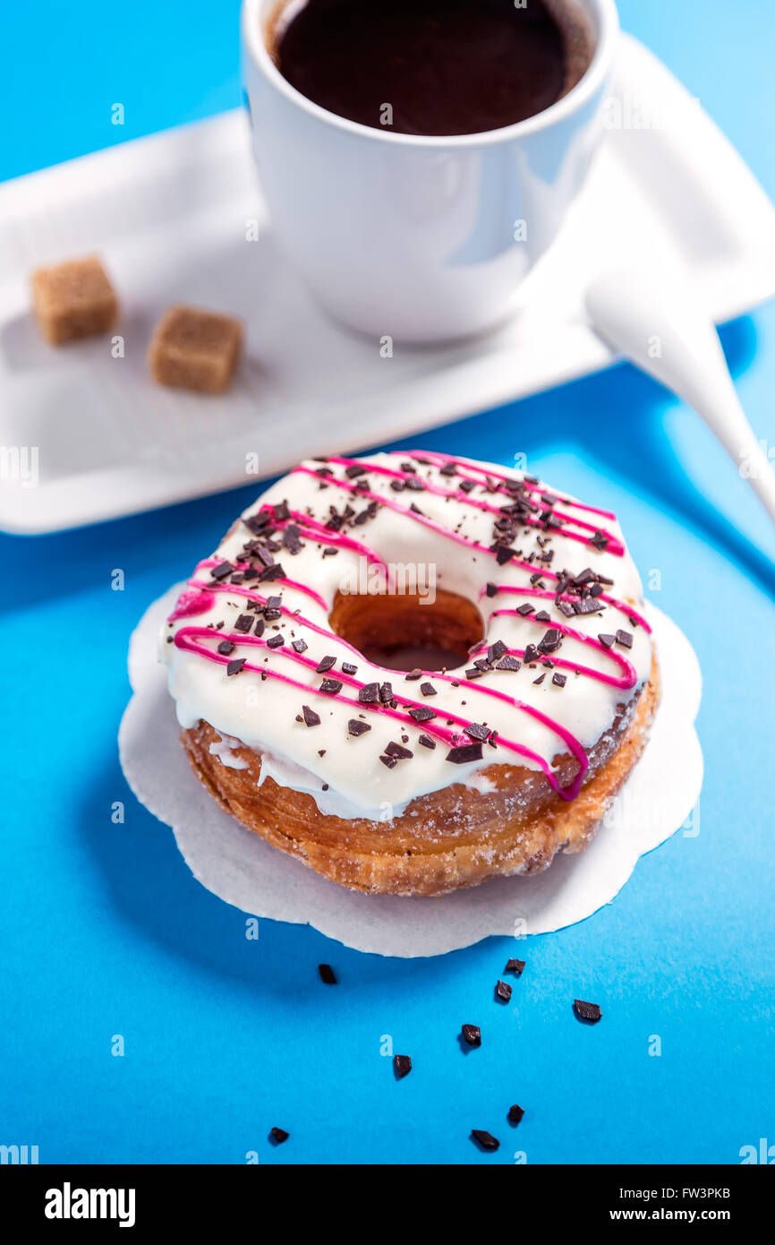 Donut glazed and coffee on blue background Stock Photo - Alamy