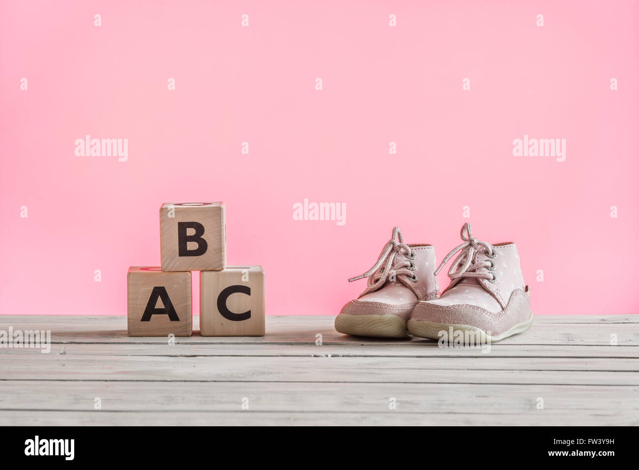 Baby shoes learning how to walk on pink background Stock Photo - Alamy