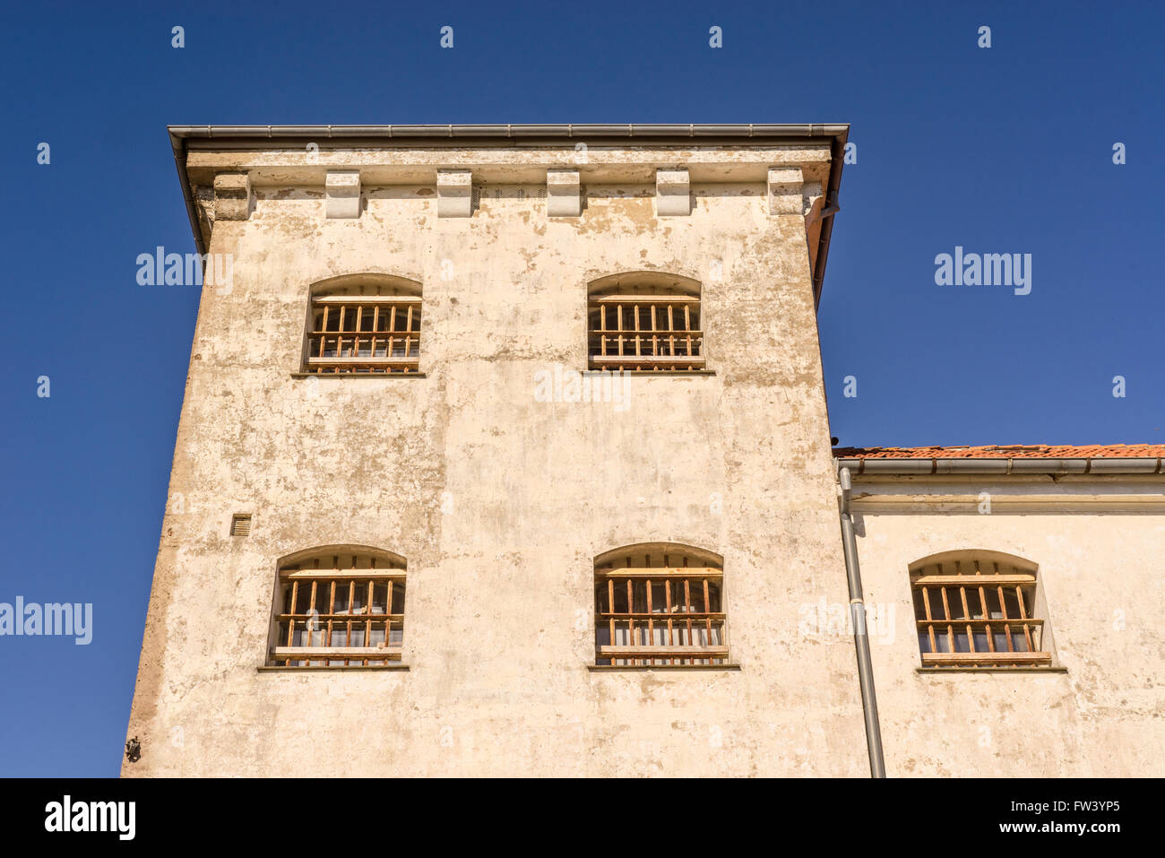 Prison building with bars on windows in spanish style Stock Photo